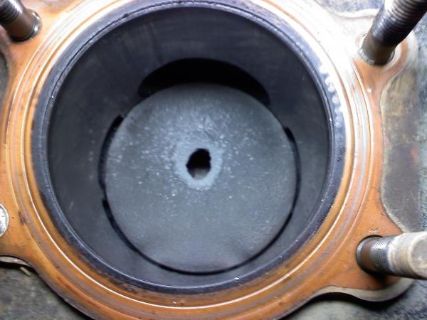 Hole blown through to of piston. Bad oil injection system.